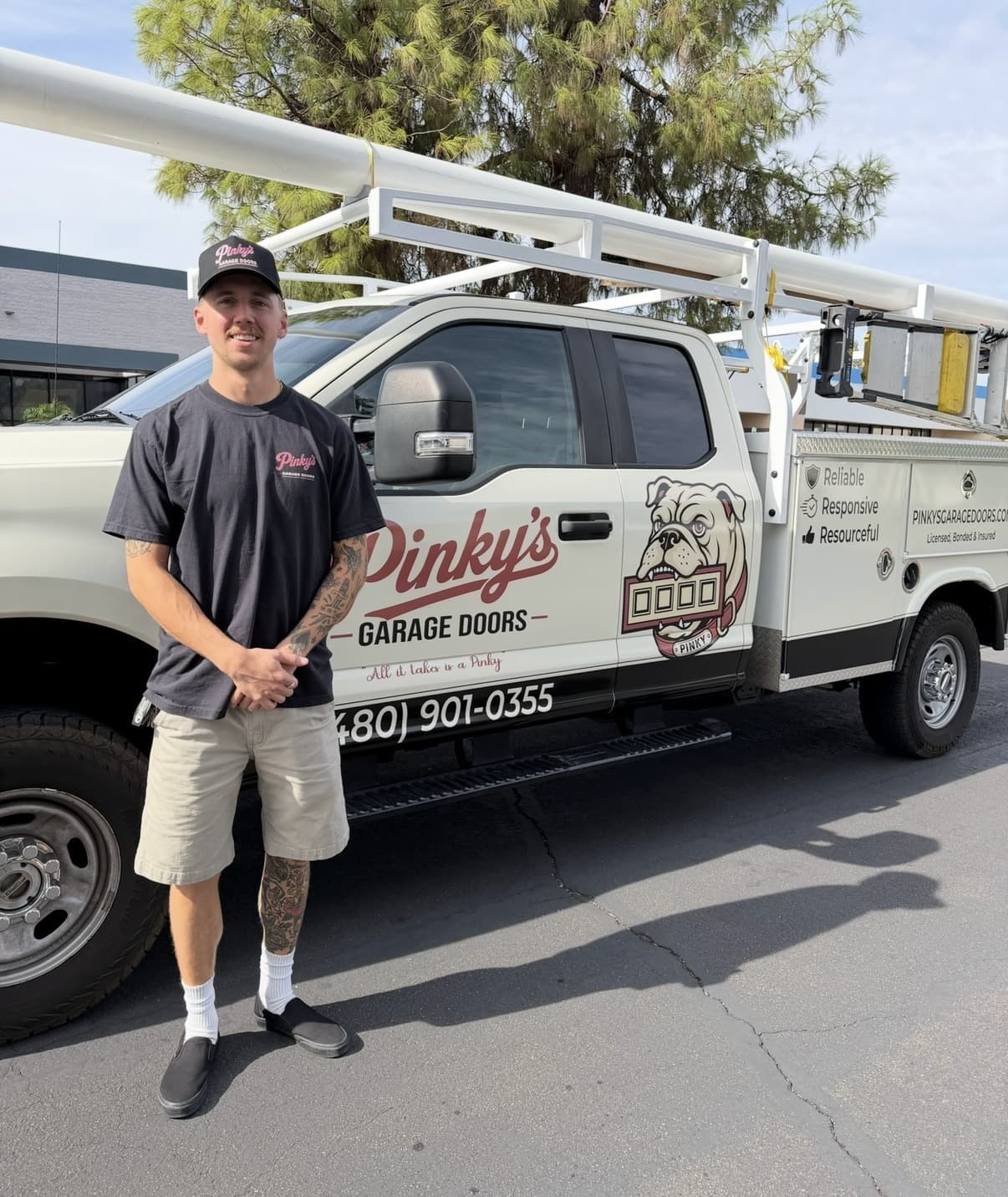 A Pinky's Garage Doors technician standing in front of the company service truck